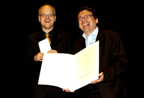 Verleger Joachim Neuß und Redakteur Thomas Geiger mit der Preisurkunde